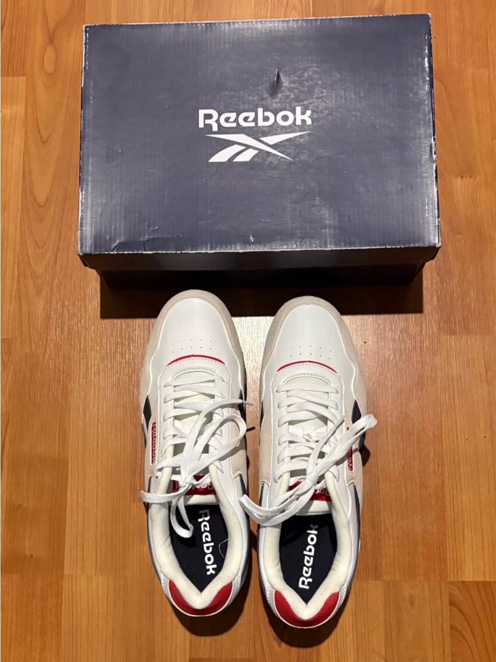 Reebok Menโs White Sneakers with Red and Black Accents